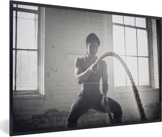 Fotolijst incl. Poster - Een vrouw is aan het fitnessen met twee touwen - 30x20 cm - Posterlijst