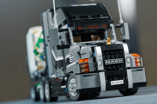 Grijze LEGO Technic Mack Anthem truck met witte container. Detail van de voorkant.