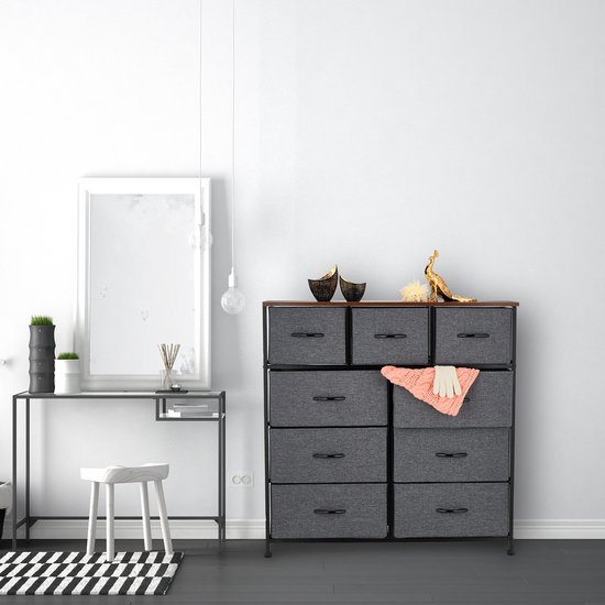 Dressoir met 9 grijze lades, houten top en zwart frame, in een slaapkamer.