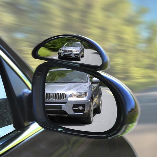 Zilveren auto weerspiegeld in een dodehoekspiegel gemonteerd op de zijspiegel van een auto.