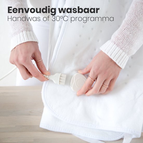 Handen bevestigen de witte elektrische deken met een stekker en de afneembare bediening.