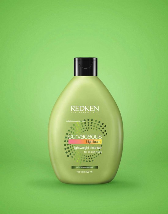 Lichtgroene fles met een zwarte dop. Redken Curvaceous high foam shampoo op een groene achtergrond.