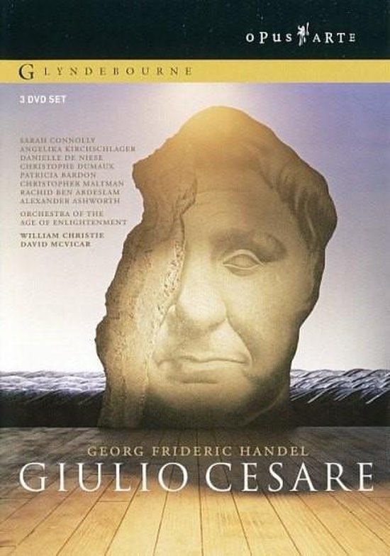 DVD set van Giulio Cesare met een beeld van een gezicht in steen voor een zonnige achtergrond.
