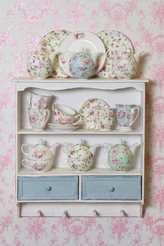 Houten wandrek met roze bloemetjes en blauwe lades, gevuld met theepotten, kopjes, schoteltjes en borden.