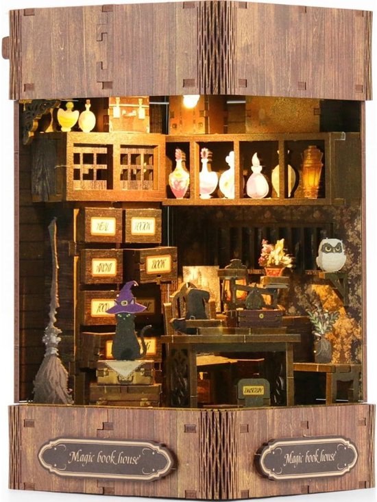 Een verlicht miniatuur huisje met een zwarte kat, een bezem, en magische flessen.