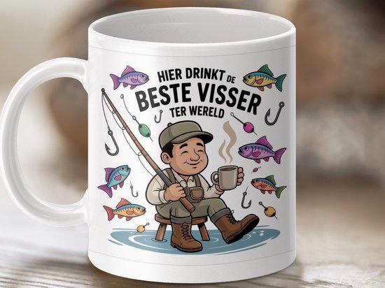 Witte mok met een tekening van een visser met een hengel en een kopje koffie, omringd door vissen en de tekst "HIER DRINKT DE BESTE VISSER TER WERELD".