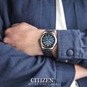 Zilverkleurig Citizen horloge met blauwe wijzerplaat met textuur, gedragen om de pols.
