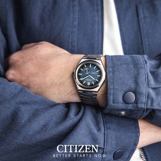 Zilverkleurig Citizen horloge met blauwe wijzerplaat met textuur, gedragen om de pols.