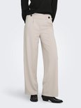 Model met beige wijde broek met knopen en zwarte coltrui, zicht op de voorkant.