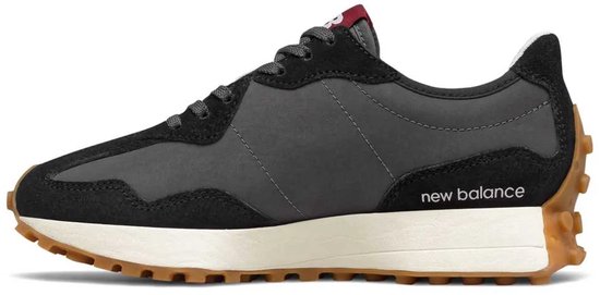 Zwarte New Balance sneaker met grijze panelen, witte zool en bruine profielzool. Tekst 'new balance' op zijkant.