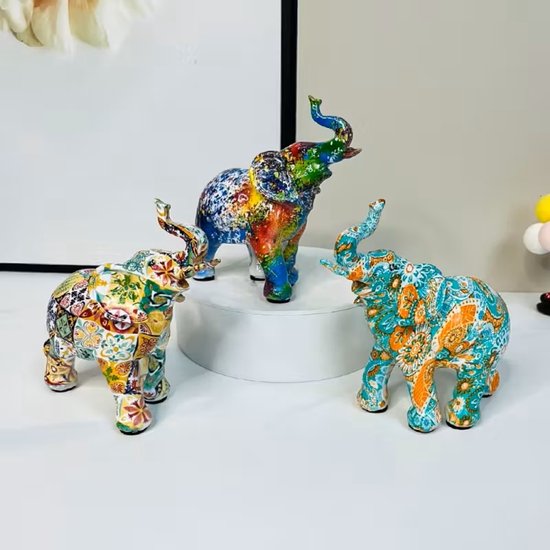 Drie kleurrijke olifantbeeldjes met verfspatten en mozaïekpatronen.