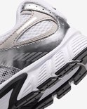 Close-up van de zijkant van een witte Nike sneaker met zilveren en grijze details.