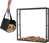 Zwarte, metalen, open haardhoutrek met op de grond gestapeld hout, afgezet met een zwarte draagtas gevuld met hout.
