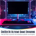 Een game-opstelling met een monitor, toetsenbord, muis en de Brightly XXL RGB muismat met draadloze oplader op een bureau.