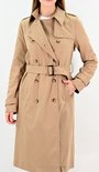 Model in camelkleurige lange trenchcoat met ceintuur en knopen.
