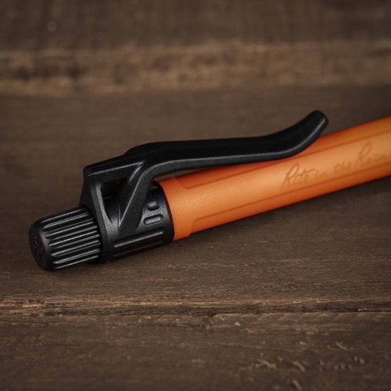Oranje pen met zwarte clip en dop, liggend op een houten ondergrond. Tekst 'Rite in the Rain' zichtbaar.