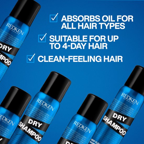 Vier blauwe spuitbussen Redken Dry Shampoo op een blauwe achtergrond. Tekst zegt "Absorbs oil for all hair types".
