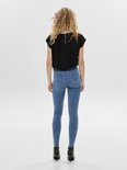 Model in een zwarte top met panterprint en een lichtblauwe skinny jeans. Achteraanzicht.