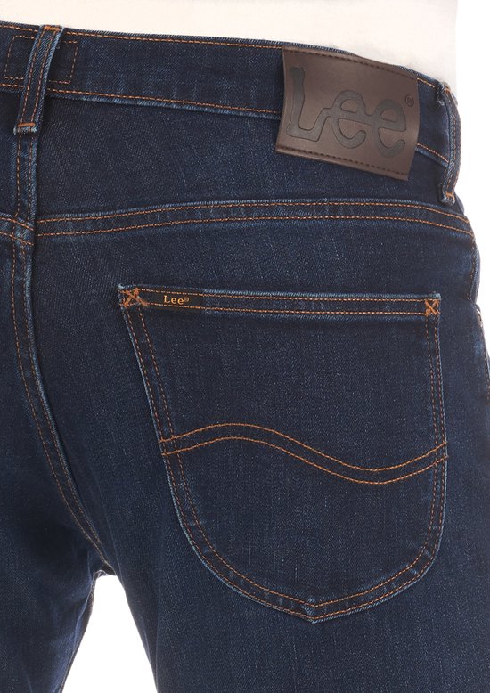Donkerblauwe jeans met bruin leren Lee-label op de achterkant.