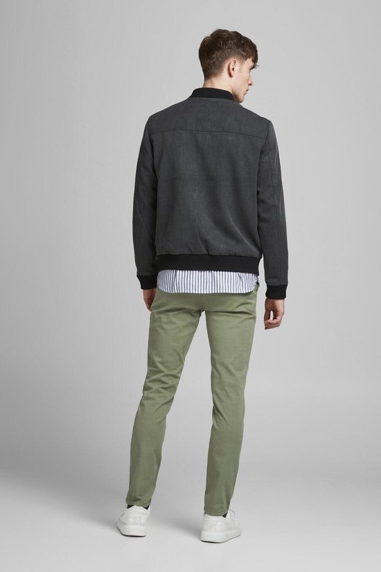 Man in lichtgroene chino, van achteren gezien.