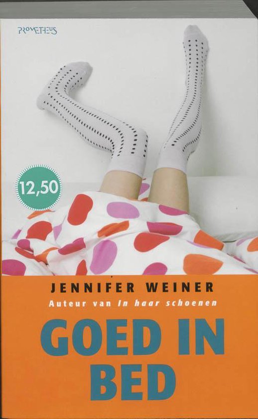 Het boek 'Goed In Bed' van Jennifer Weiner. Een vrouw ligt onder een deken met stippen, draagt een gestreepte kousen.