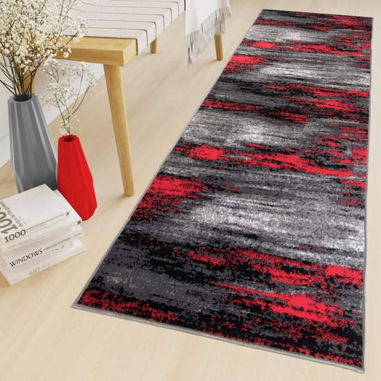 Tapis de couloir gris, rouge et noir à motif abstrait dans un décor intérieur.