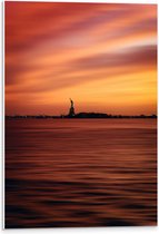 WallClassics - PVC Schuimplaat- Oranje Lucht boven Vrijheidsbeeld in New York - 40x60 cm Foto op PVC Schuimplaat