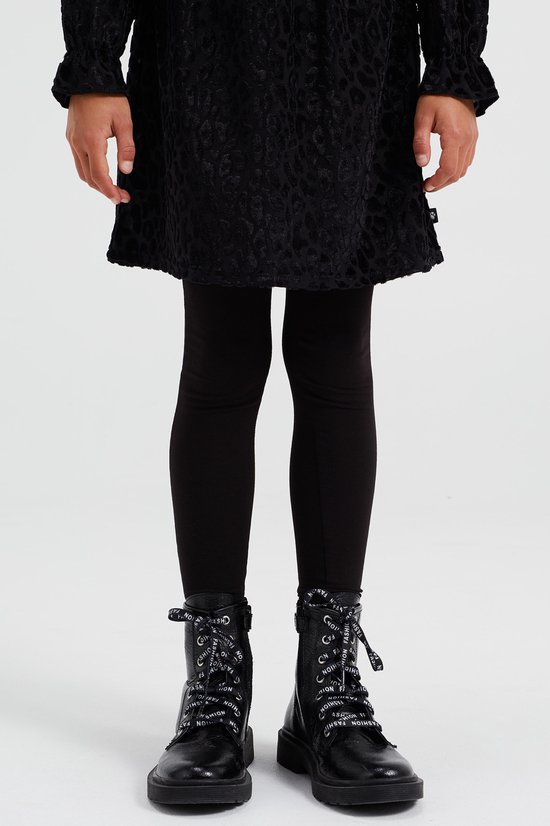 Onderlichaam van een meisje in een zwarte legging, met zwarte veterlaarsjes.