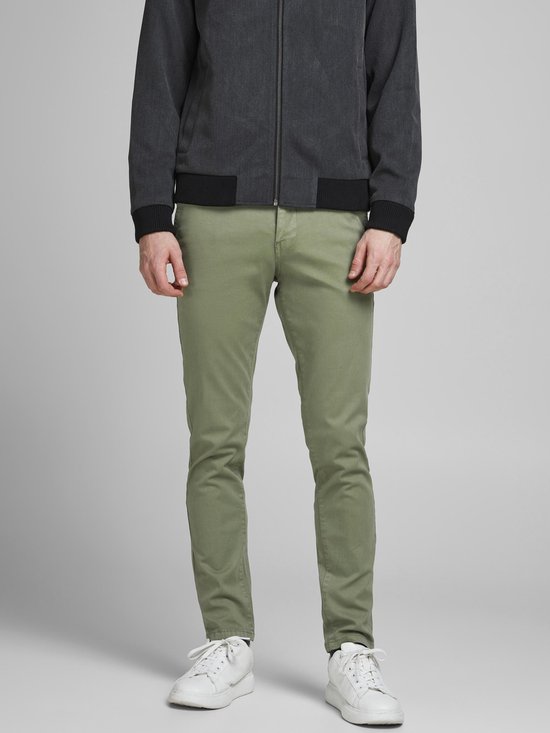 Man met smalle, lichtgroene broek en donkergrijs jack.