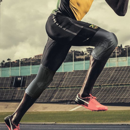 Lopende atleet op een baan met een grijze Chibaa kniebrace aan beide benen.