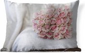 Sierkussen Roze roos voor buiten - Dit rozenboeket ligt op een bankje met wit kleed - 50x30 cm - rechthoekig weerbestendig tuinkussen / tuinmeubelkussen van polyester
