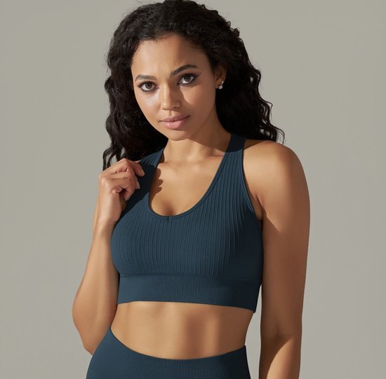 Model dat een blauwgrijze sportbeha met ribbeltextuur draagt.