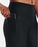 Dames plaatsen een smartphone in de zak van een zwarte capri sportbroek.