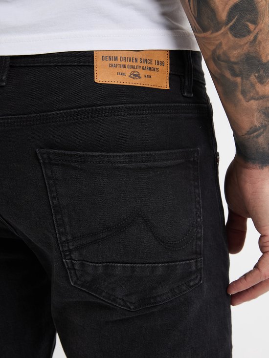 Close-up van de achterzak van een zwarte jeans met Petrol Industries label.