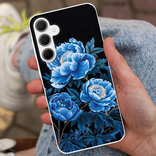 Personne tenant une coque de téléphone avec de grandes pivoines bleues sur fond noir.