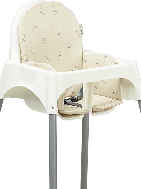 Witte hoge stoel met grijze poten en een beige stoelverkleiner met ginkgo print.