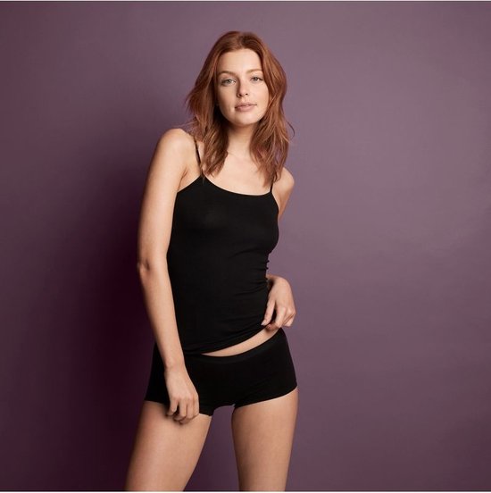 Model met spaghettibandjes top en zwarte shorts.