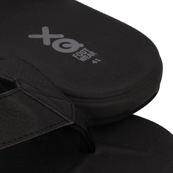 Close-up van zwarte XQ teenslippers, focus op de band en het gestructureerde voetbed.