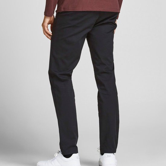 Man in donkerblauwe chino broek en bordeaux trui, achterkant.