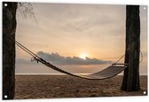 Tuinposter – Houten Hangmat tussen Hoge Bomen op het Strand bij Ondergaande Zon - 120x80 cm Foto op Tuinposter (wanddecoratie voor buiten en binnen)