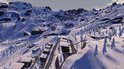 Brede opname van een besneeuwde berg met ski-resort, huizen en bomen.