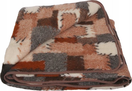 Een opgevouwen wollen deken in patchwork-stijl met bruine, grijze en witte blokken met een bruine bies.