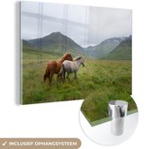 MuchoWow® Glasschilderij 120x80 cm - Schilderij acrylglas - Paarden - Gras - Bergen - Foto op glas - Schilderijen