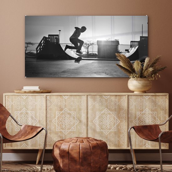 Peinture sur verre MuchoWow® - Un garçon fait une cascade avec son skateboard pendant le coucher du soleil - noir et blanc - 120x60 cm - Peintures sur verre acrylique - Photo sur Glas