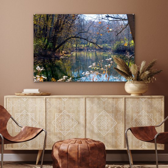 Acrylglas schilderij van een rivier in een herfstbos. Zonnestralen breken door de bomen. Duidelijke reflecties in het water.