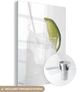 MuchoWow® Glasschilderij 30x40 cm - Schilderij acrylglas - Een glas gin-tonic en schijfjes limoen - Foto op glas - Schilderijen
