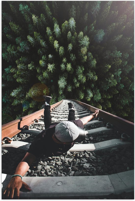 Poster Glanzend – Man Hangend aan Spoor boven de Bomen - 80x120 cm Foto op Posterpapier met Glanzende Afwerking