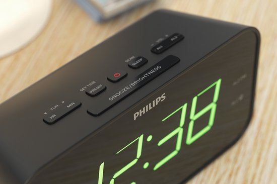 Close-up van de zwarte Philips wekkerradio met groene digitale cijfers en knoppen.