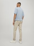 Man met korte mouwen lichtblauwe polo en beige chino.