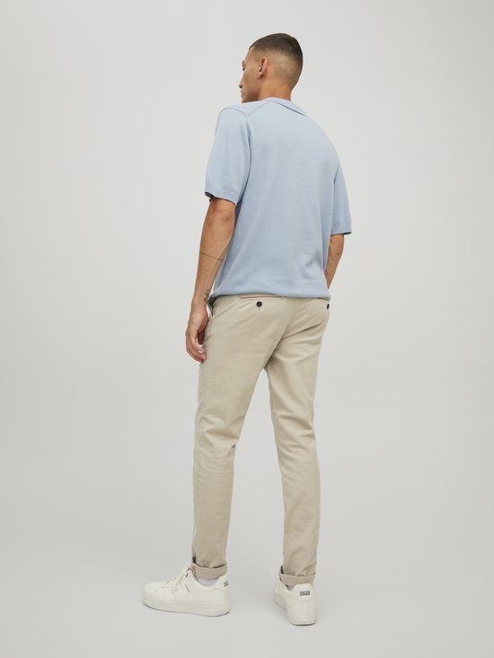 Man met korte mouwen lichtblauwe polo en beige chino.